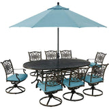 Hanover Outdoor Dining Set Hanover Traditions 9-Piece Dining Set in Blue with 8 Swivel Rockers, 95-in. x 60-in. Oval Cast-Top Table, Umbrella and Umbrella Stand