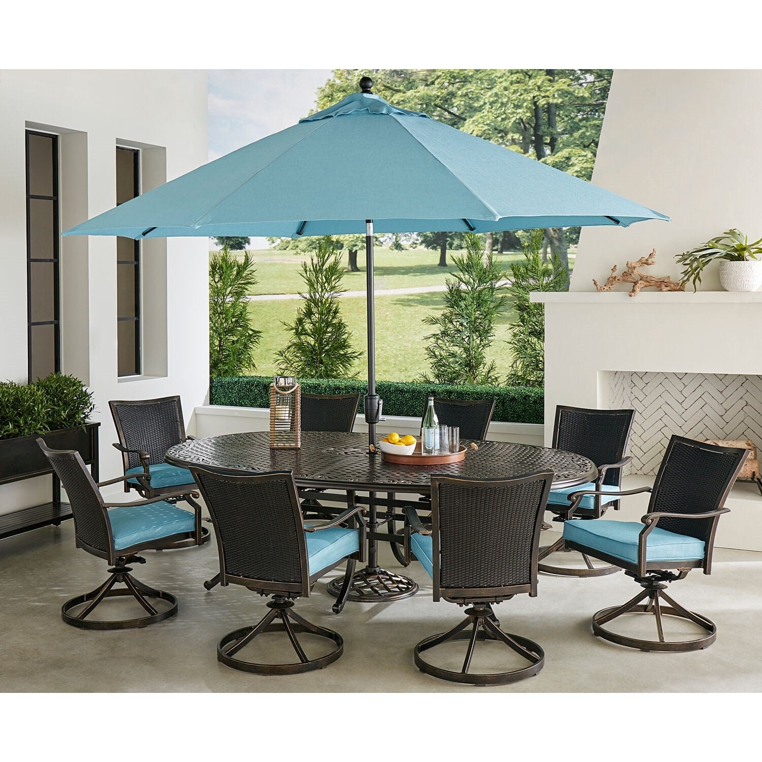 Hanover Outdoor Dining Set Hanover Traditions 9-Piece Set in Blue with 8 Wicker Back Swivel Rockers, 95-in. x 60-in. Oval Cast Dining Table, Umbrella and Stand